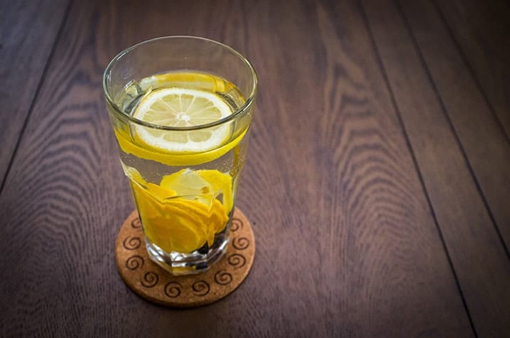 glass of water with sliced lemons in it