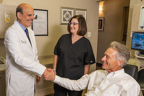 Blue Bell implant dentist Dr. Siegel shaking the hand of a happy male patient
