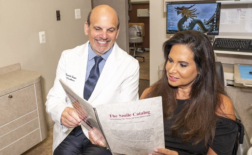 Dr. Siegel with his patient, discussing a smile makeover